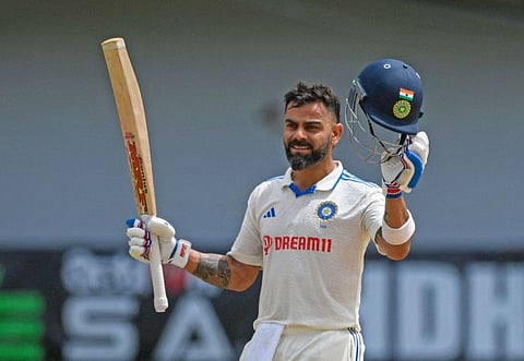 India's Virat Kohli raises his bat celebrating his century on the second day of the second Test against West Indies at Queen's Park Oval, in Port of Spain on Friday.