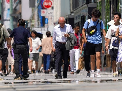 Pedestrians walk during heatwave conditions in Tokyo on July 18, 2023.  