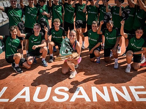 Italy's Elisabetta Cocciaretto celebrates with the trophy and ball kids after winning against France's Clara Burel in Lausanne on Sunday.
