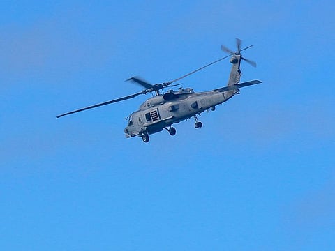 A Royal Australian Navy helicopter conducts search and rescue operations for the crashed chopper over the weekend. 