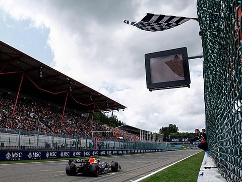 A  race marshal waves the checkered flag as Red Bull Racing's Dutch driver Max Verstappen crosses the finish line to win the Belgian Grand Prix at the Spa-Francorchamps Circuit in Spa on Sunday.