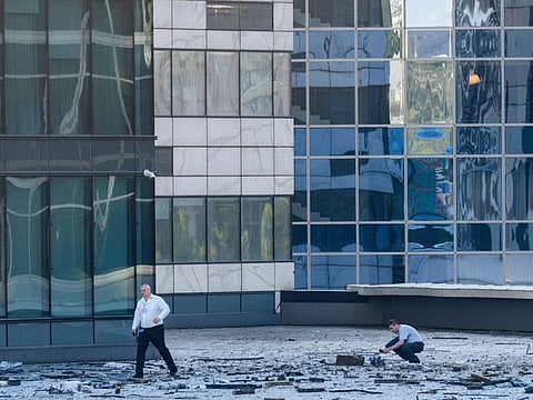 Investigators examine an area next to damaged building in the "Moscow City" business district after a reported drone attack in Moscow, Russia, on August 1, 2023.  
