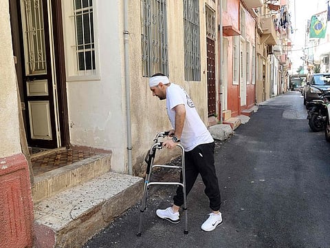 Dany Salameh uses a walker as he takes a stroll on a street in the Lebanese capital.