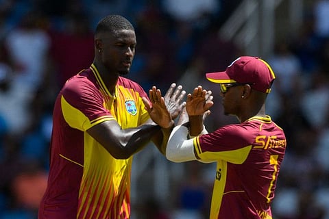Jason Holder (left) and Akeal Hosein of West Indies celebrate the dismissal of Hardik Pandya of India during the first T20I match at Brian Lara Cricket Academy in Tarouba, Trinidad and Tobago, on Thursday.