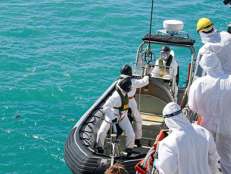 Sailors from HMAS Brisbane prepare to board a rigid-Hulled inflatable boat to conduct search and rescue operations in the vicinity of Lindeman Island, Australia