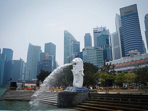 File photo: The Merlion statue spouts water at a park with the background of a business district in Singapore.