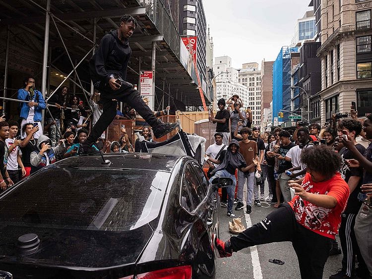 People jump on a car during riots sparked by Twitch streamer Kai Cenat, who announced a "givaway" event, in New York's Union Square. 