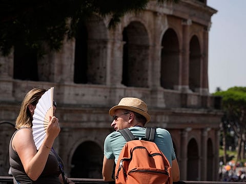 Tourists stops in front of the Colosseum in Rome, July 17, 2023.