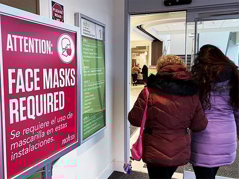 A sign announcing a face mask requirement is displayed at a hospital in Buffalo Grove, Illinois. COVID-19 hospital admissions are inching upward in the United States since early July 2023. It’s a small-scale echo of the three previous summers. 