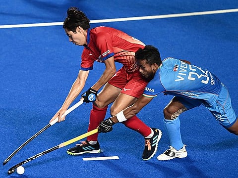 Japan's Genki Mitani (L) fights for the ball with India's Vivek Sagar Prasad during the Asian Champions Trophy 2023 hockey tournament semifinal match at the Mayor Radhakrishnan Stadium in Chennai on August 11, 2023. 