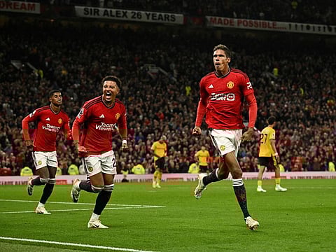 Manchester United's Raphael Varane celebrates scoring their first goal with Jadon Sancho during a Premier League match against Wolves on Monday.
