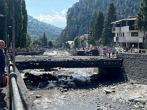 Thick mud and debris cover streets and the river bed following a mountain mudslide, which caused the flooding of a stream in Bardonecchia, a city near Turin in the Val di Susa mountain valley, Italy, Monday, Aug. 14, 2023. 
