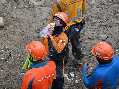 A construction worker drinks water during hot weather in Hong Kong.