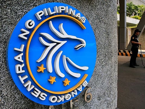 A security guard stands beside a logo of the Bangko Sentral ng Pilipinas (Central Bank of the Philippines) posted at the main gate in Manila, Philippines April 28, 2016.