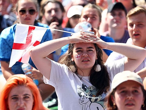England fans in Victoria Park react as they watch the match on a big screen.