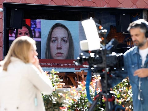 Members of the media work near a large screen showing a picture of convicted hospital nurse Lucy Letby, ahead of her sentencing, outside the Manchester Crown Court, in Manchester, Britain, August 21, 2023.