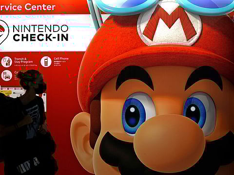 File photo: A person passes an ad featuring the Nintendo character Mario at Narita airport in Narita near Tokyo. Charles Martinet, the voice of Mario in Nintendo games since the 1990s, is stepping down, Nintendo of America confirmed. 