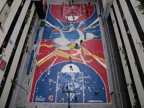 People play basketball on a court painted with the Fiba Basketball World Cup theme on Thursday in Taguig city Philippines.