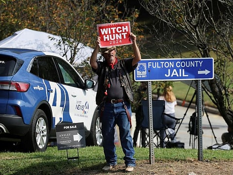 A man, calling himself "hat man", stands near the entrance to Fulton County Jail, as former US President Donald Trump is expected to turn himself in to be processed after his Georgia indictment, in Atlanta, on August 24, 2023.  