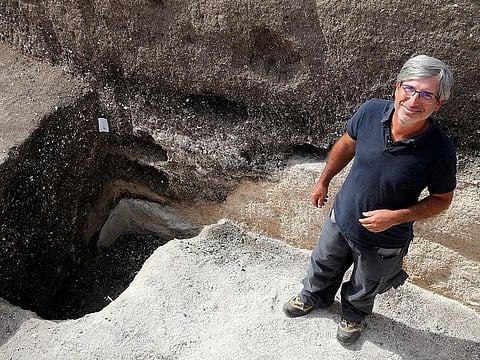 Remi Martineau, researcher at the CNRS, stands at the mouth of a well, dating from the Modern Neolithic, around 3500-years-ago.