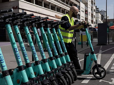 An employee loads electric scooters in a van in Paris.