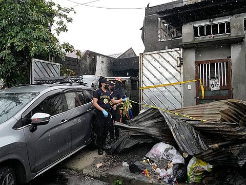 Police arrange a tape outside a factory that caught fire in Quezon city, Philippines on Thursday, Aug. 31, 2023.