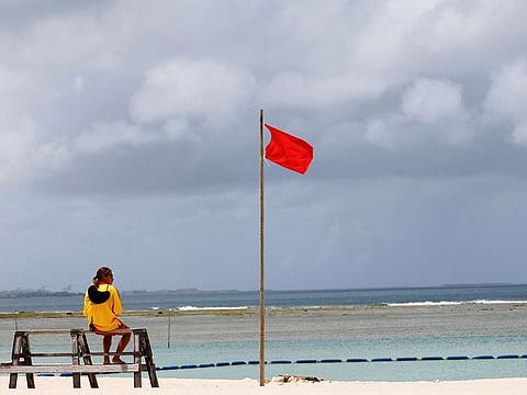  A lifesaver keeps watch next to a red flag designating the prohibition of swimming as Typhoon Haikui approaches the region, at Sunset Beach in Chatan, Okinawa prefecture, Japan September 1, 2023.