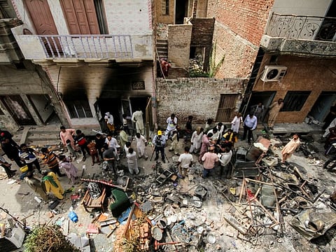 People and members of the media gather along a street in a Christian neighbourhood, a day after the church buildings and houses were vandalised by protesters in Jaranwala on August 17, 2023.  