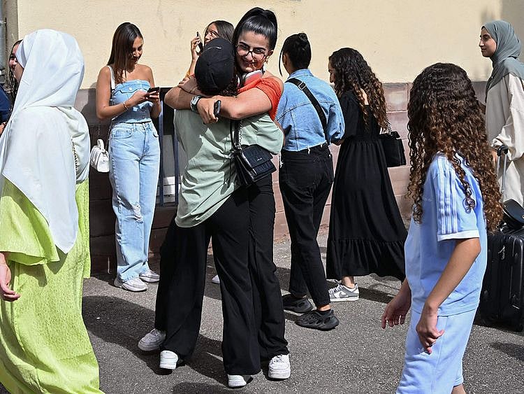 Students check the results of the French general baccalaureate examinations (high school graduation) at the Pasteur high school in Strasbourg, eastern France. The French government's decision to ban schoolgirls wearing abayas has opened a fresh debate about the country's secular laws and the treatment of Muslim minorities.