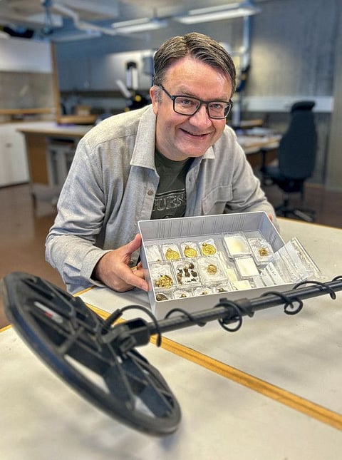 Amateur archaeologist Erlend Bore posing with a gold treasure photographed shortly after he found it with the help of a metal detector on the island of Rennesoy in Stavanger.  