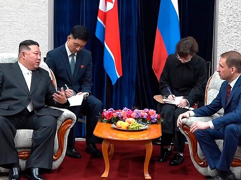 North Korea's leader Kim Jong Un, left, gestures as he speaks to Russian Minister of Natural Resources and Ecology Alexander Kozlov, right, after crossing the border to Russia at Khasan, about 127 km (79 miles) south of Vladivostok.  