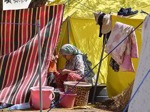 A woman sits outside her tent at a camp for locals displaced by a devastating earthquake in Amizmiz.