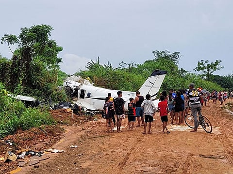 People look at the aircraft after it crashed, which has left 14 dead in Barcelos, Amazonas State Brazil.