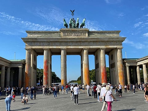 People walk in front of the Brandenburg Gate after Last Generation ("Letzte Generation") climate activists threw paint on the columns of the Brandenburg Gate in Berlin, Germany.