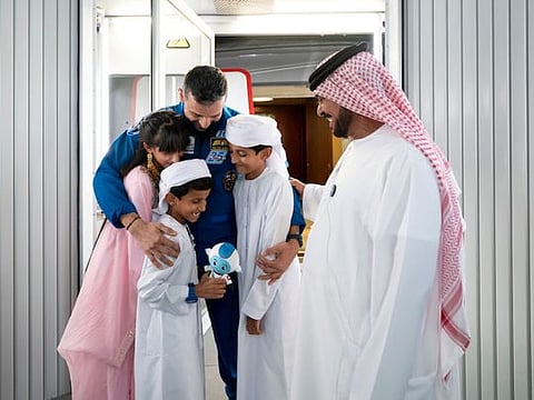 UAE Astronaut, Sultan Al Neyadi (C), greets his father Saif Al Neyadi (R) and his children during a homecoming reception at the new Abu Dhabi international airport.