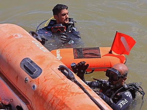Members of the UAE rescue team dive in the sea to retrieve bodies in Libya's eastern port city of Derna on September 18, 2023,  
