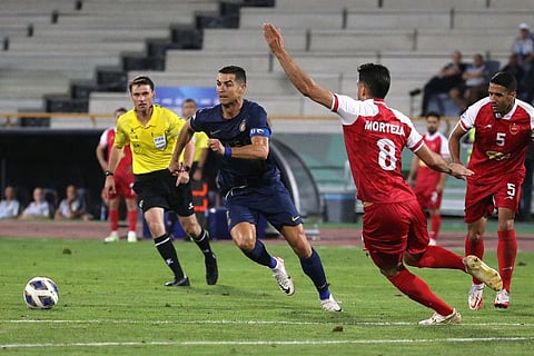 Nassr's Portuguese forward Cristiano Ronaldo and Persepolis' Iranian defender Morteza Pouraliganji vie for the ball during the AFC Champions League group E match at Tehran's Azadi stadium on Tuesday.