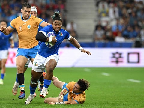 Italy's full-back Paolo Odogwu breaks through a tackle from Uruguay's fly-half Felipe Etcheverry (right) during the Rugby World Cup Pool A match at Stade de Nice in Nice, southern France on Wednesday.