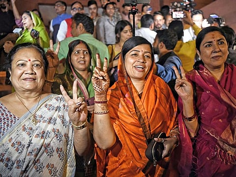 Indian women MPs, including Riti Pathak, flash the victory sign after Lok Sabha passed the motion on the Women's Reservation Bill during the Special Session at the Parliament in New Delhi on September 20, 2023. 