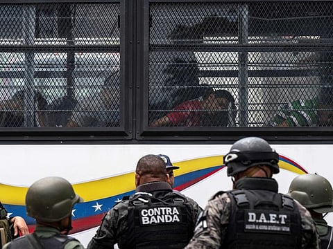 Members of the Bolivarian National Guard (GNB) stand guard as inmates aboard a bus are transferred outside the Tocoron prison in Tocoron, Aragua State, Venezuela, on September 20, 2023.  