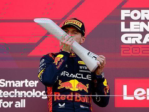 Red Bull's Max Verstappen celebrates with a trophy on the podium after winning the Japanese Grand Prix.