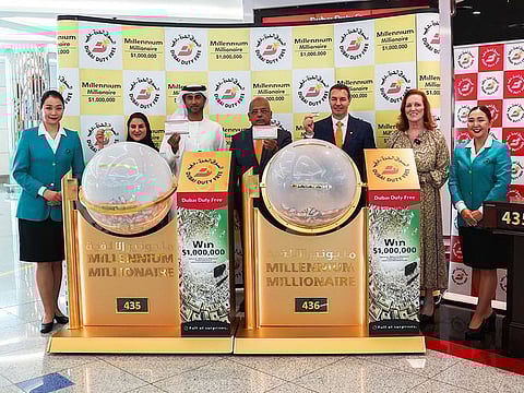 Dubai Duty Free representatives showing the two tickets that won $1 million each