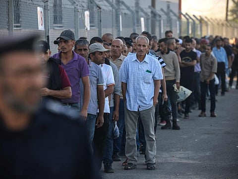 Palestinian workers gather at the Erez crossing between Israel and the northern Gaza Strip, on September 28, 2023, after the crossing was reopened by Israeli authorities.  