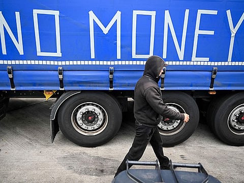 A truck driver walks past the lettering "No Money" on a truck outside Frankfurt am Main, western Germany.