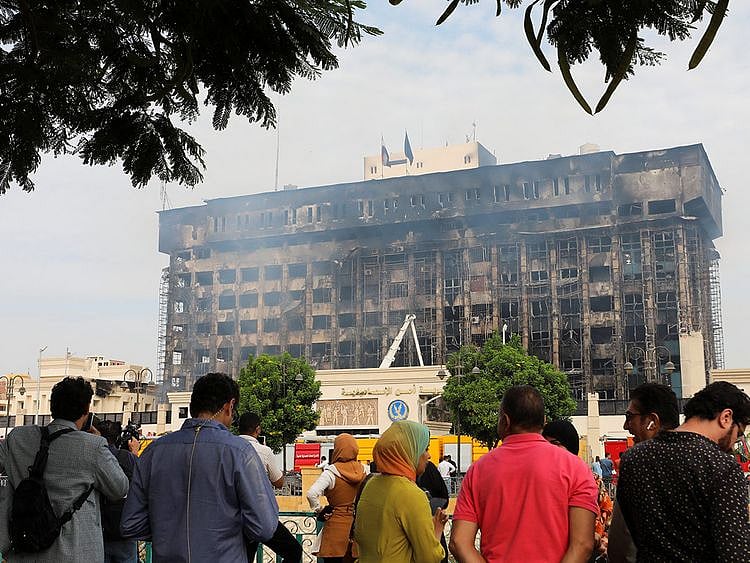 People gather near a police facility where a fire broke out, in Ismailia on October 2, 2023.  