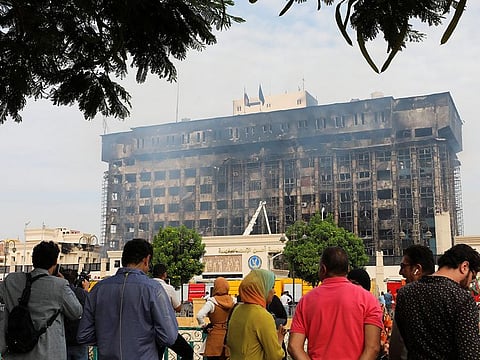 People gather near a police facility where a fire broke out, in Ismailia on October 2, 2023.  