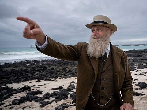 US Kenneth Noll, in the costume of the English naturalist, geologist, and biologist Charles Robert Darwin, at the beach in Puerto Ayora on Santa Cruz Island in Galapagos, Ecuador.
