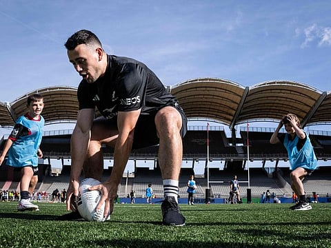 New Zealand's centre Will Jordan grabs a ball during the a public workshop with young rugby enthusiast at the Stade Gerland in Lyon, southeastern France, on Wednesday.