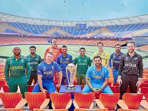 Team captains pose for a picture with the ICC Cricket World Cup trophy at the Narendra Modi Stadium in Ahmedabad on October 4, 2023. 