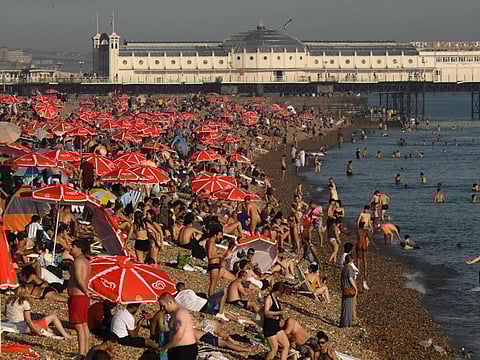 Looking towards the Palace Pier, beachgoers enjoy the sun and the sea on the beach at Brighton, on the south coast of England on September 7, 2023. Last month was the world's hottest September on record by an "extraordinary" margin, adding to record-breaking global temperatures during the Northern Hemisphere summer, the EU climate monitor said on Thursday.  
